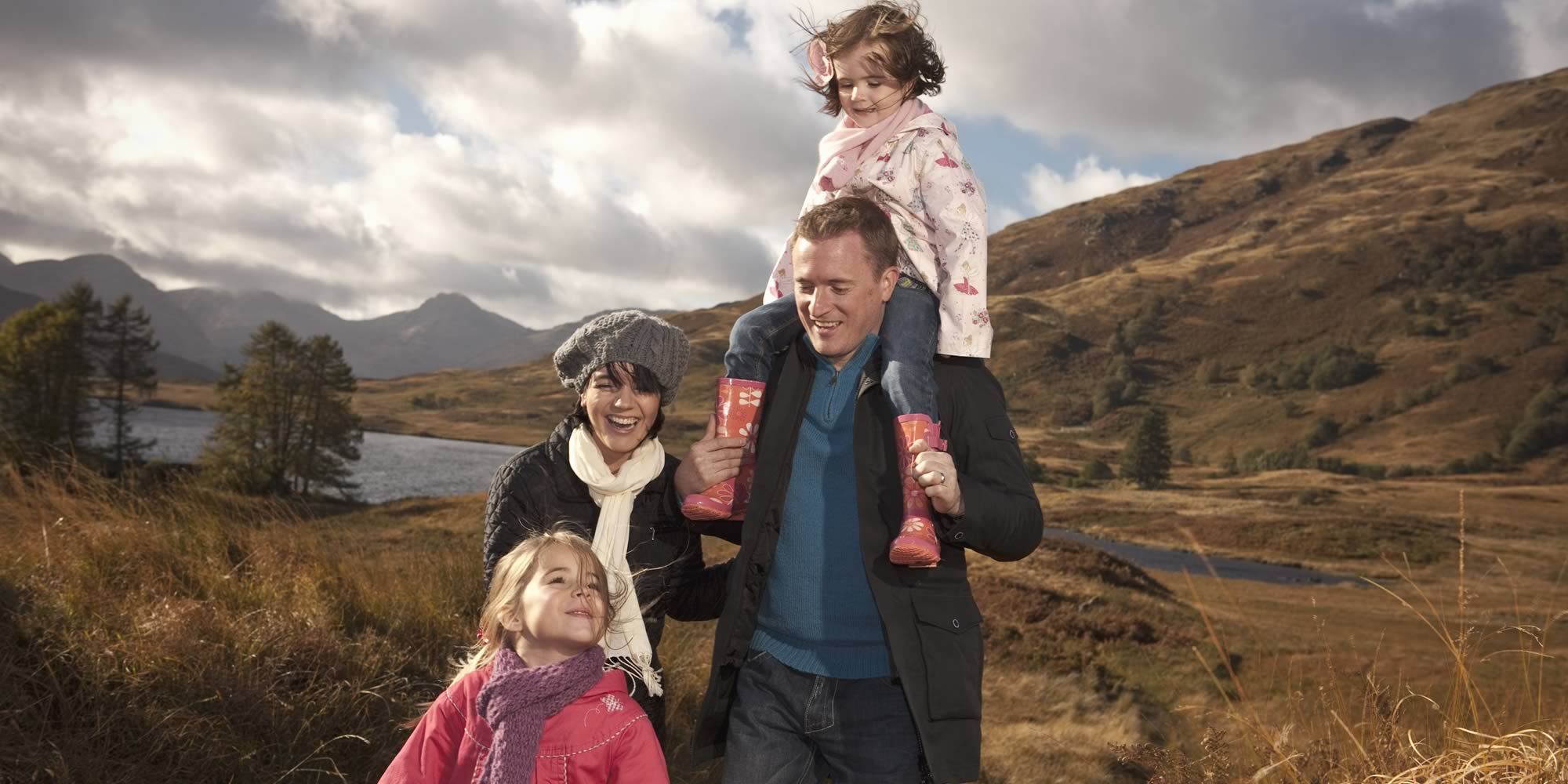 Family with two young daughters walking in mountains in winter