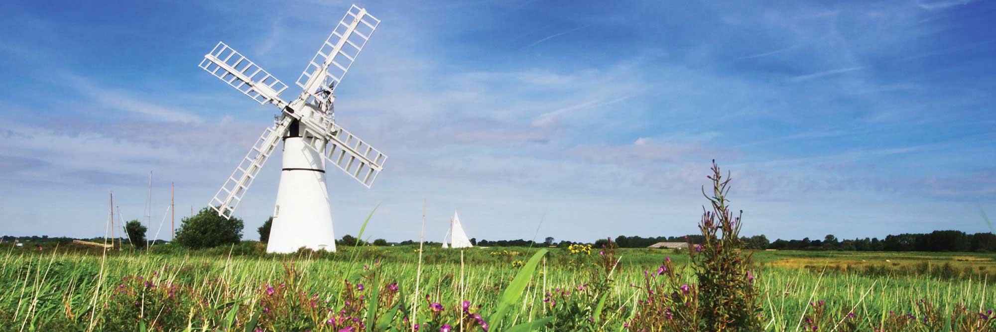 A white windmill against blue sky