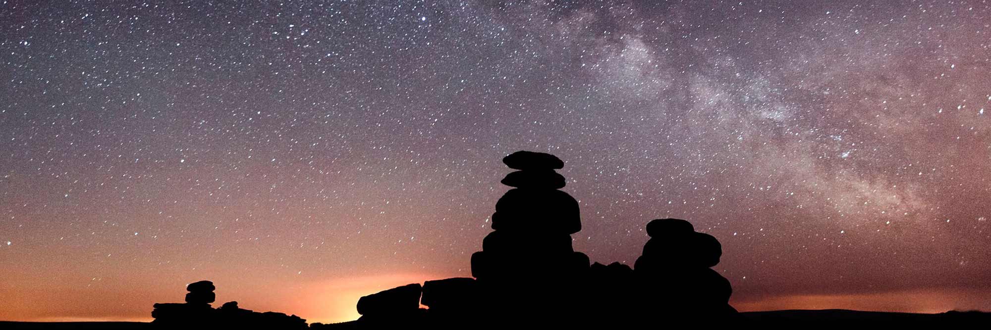 Smooth rock pillars against a starry sky at night