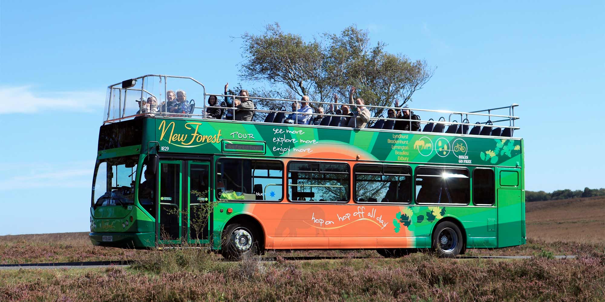 Open bus with visitors enjoying a view across open moorland