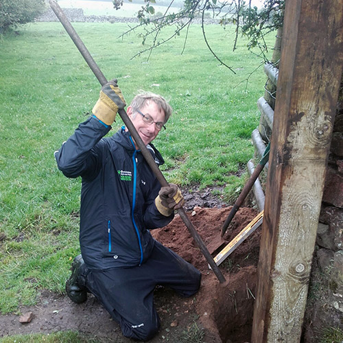 Man digging a large gatepost hole